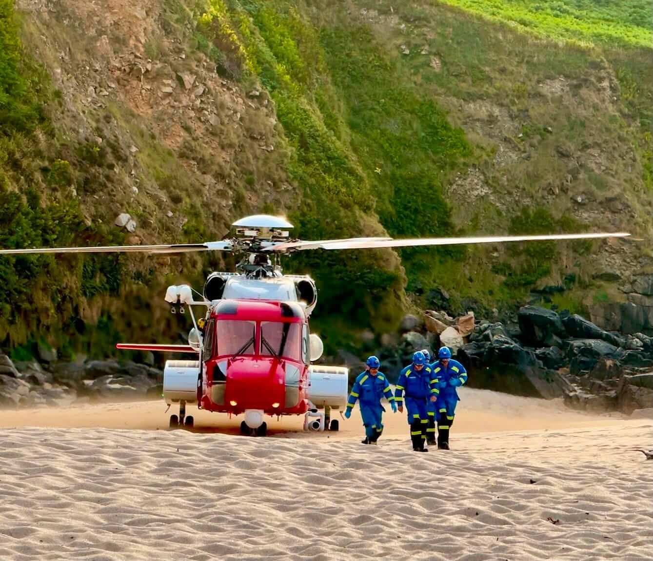 Coastguard helicopter and crew on the sand at Portheras Cove