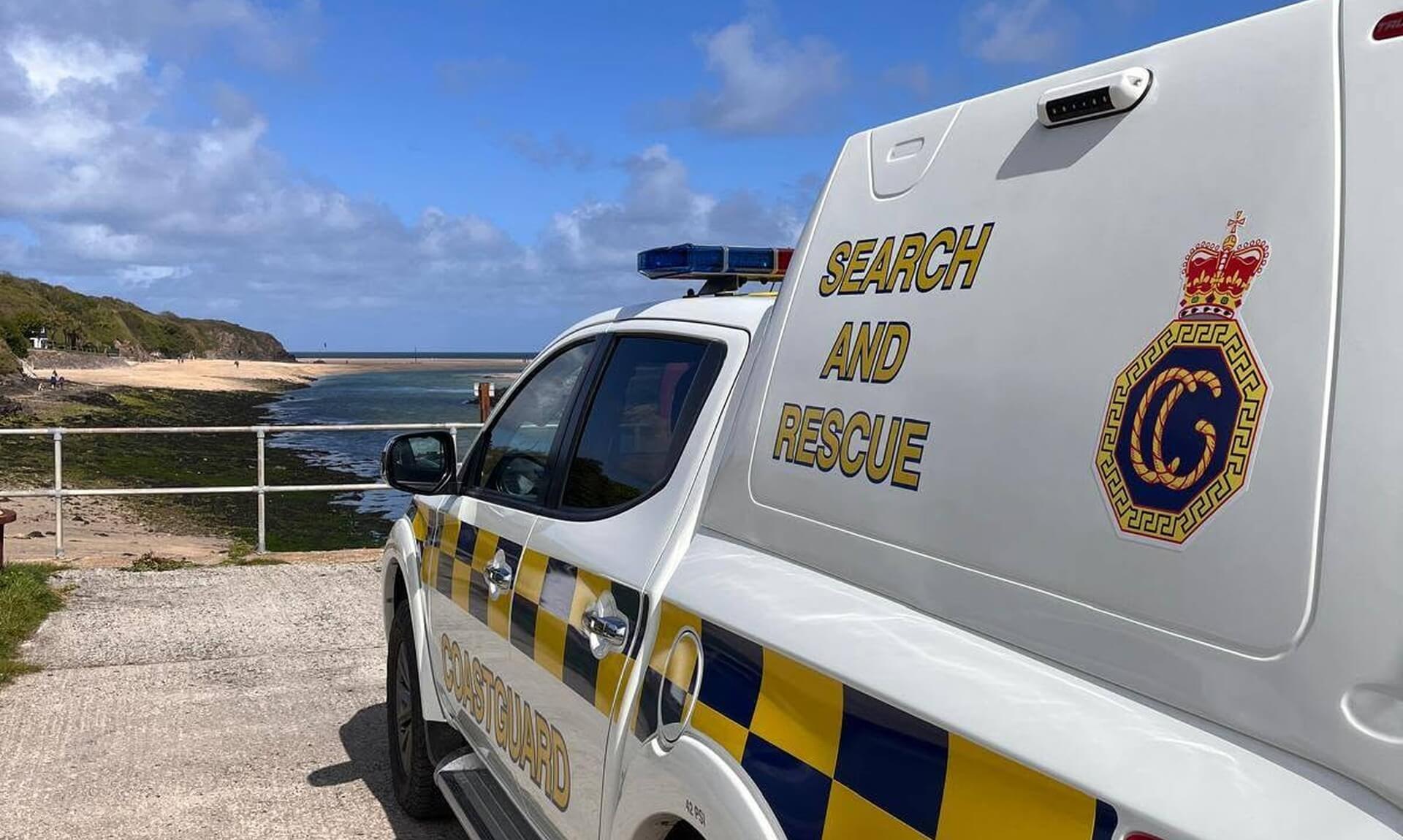 An HM Coastguard Search and Rescue vehicle parked above a Cornish beach