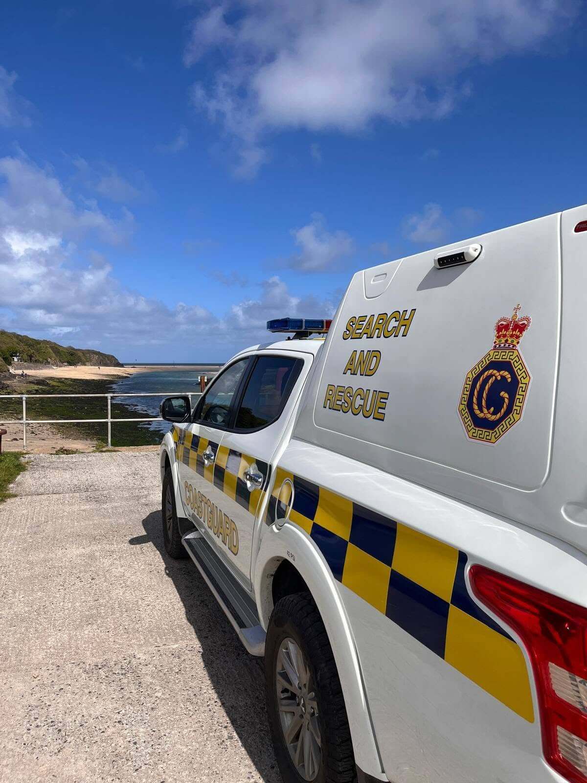 An HM Coastguard Search and Rescue vehicle parked above a Cornish beach