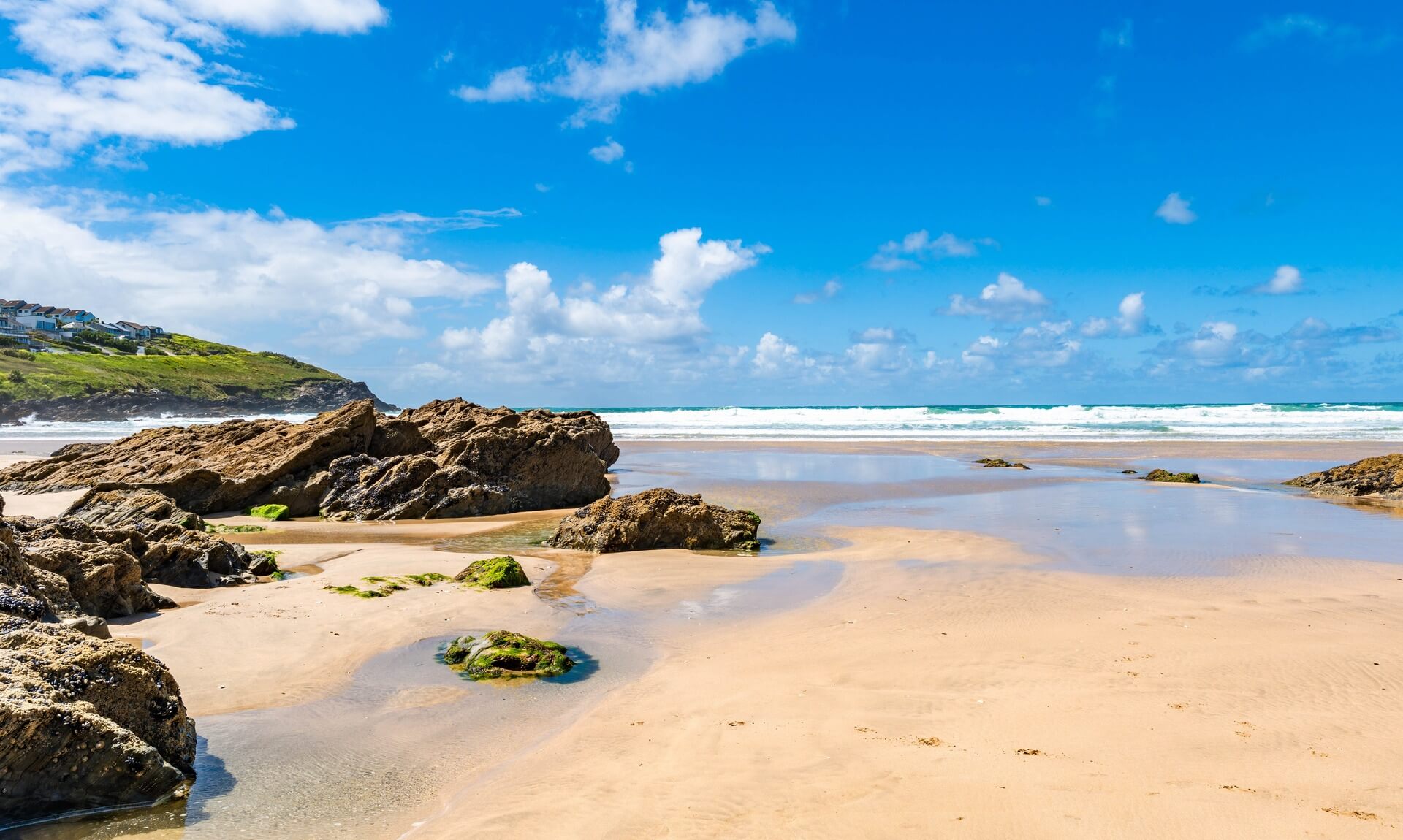 Fistral beach in Newquay at low tide under a blue sky