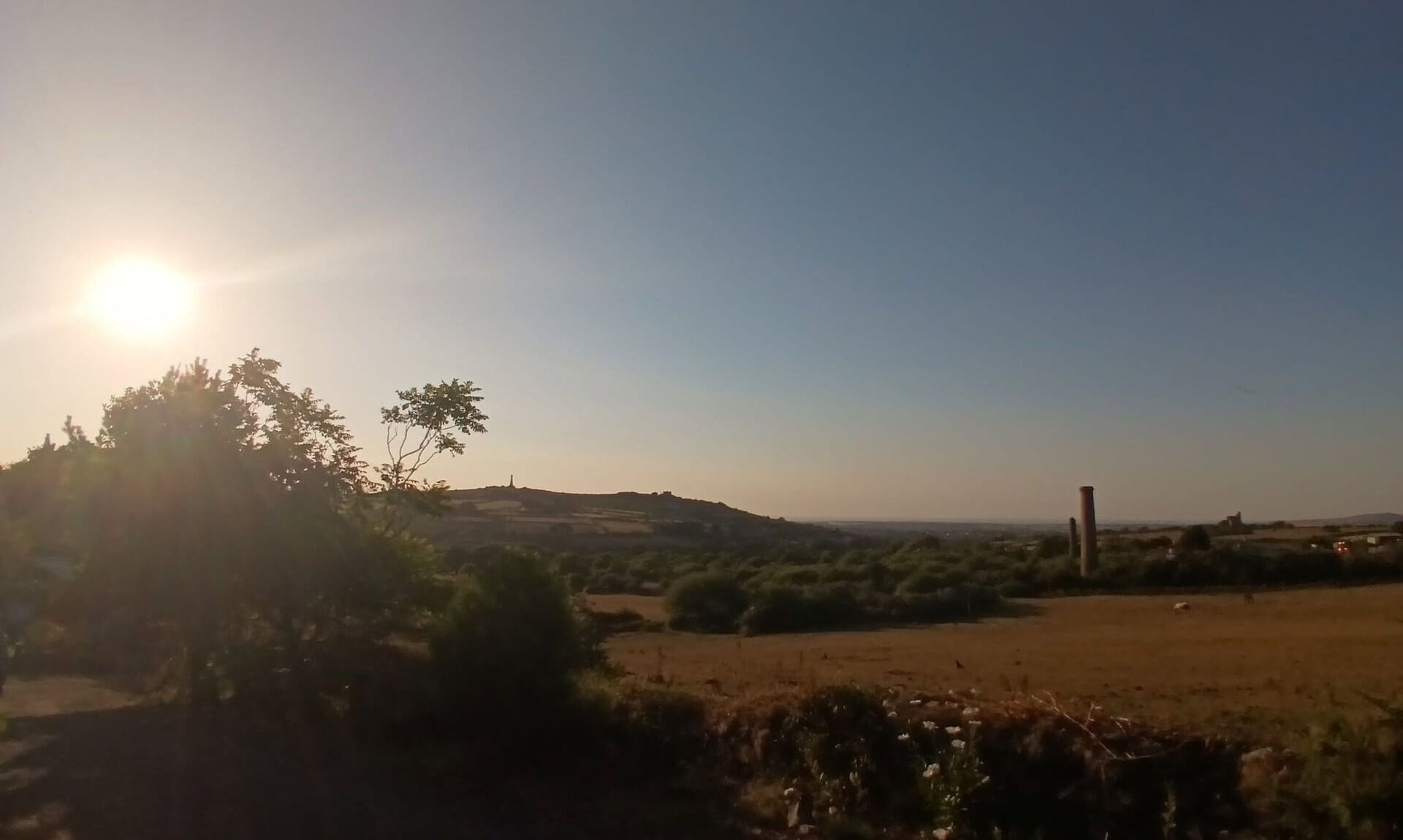 Partial solar eclipse over a Cornish mine engine house at sunset
