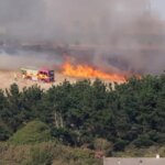 Cornwall Fire and Rescue Service fire engine beside wildfire flames at Mawgan Porth