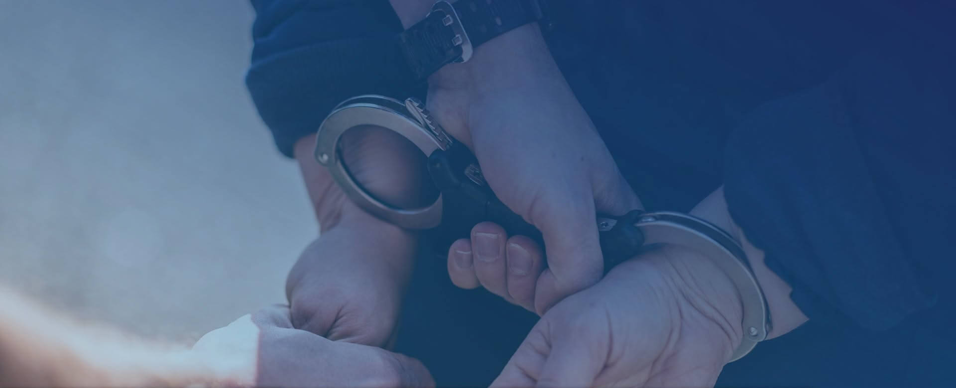 Hands in police handcuffs behind a person's back