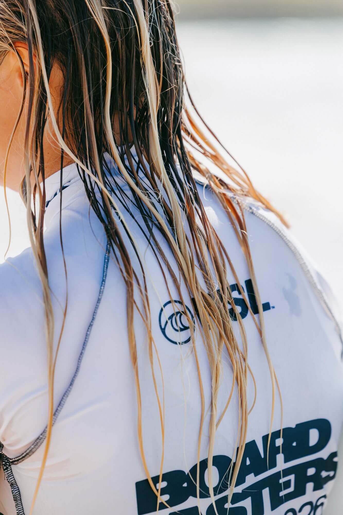 Close-up of a surfer's wet hair over a Boardmasters Open WSL jersey