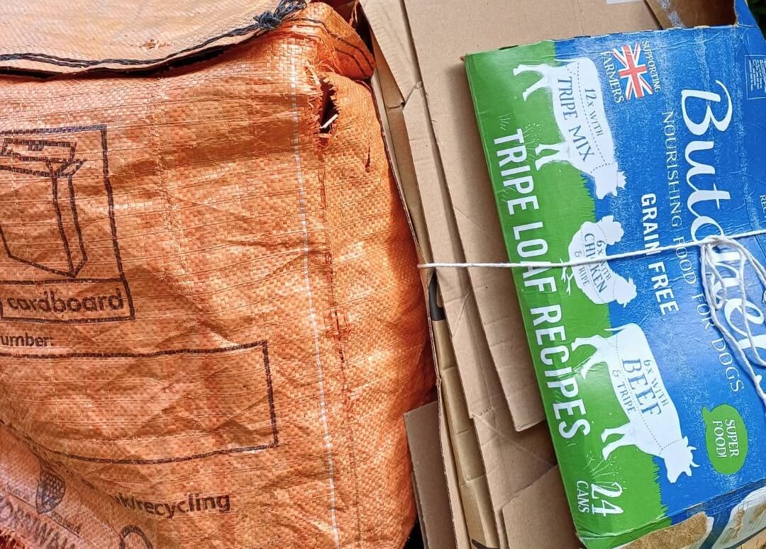 Cardboard boxes and a torn cardboard recycling bag ready for collection