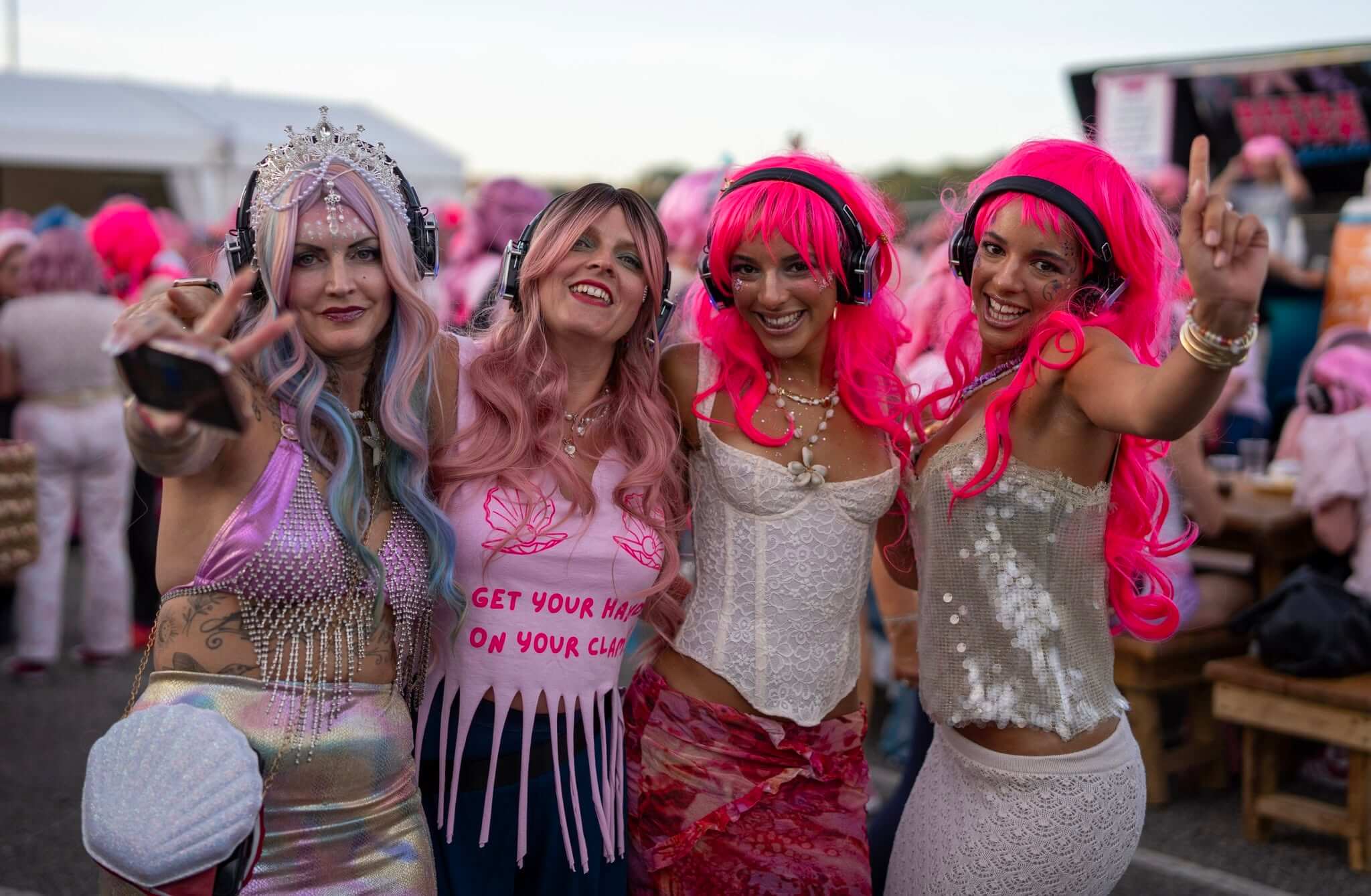 Four friends in pink and mermaid-themed wigs at the Falmouth Pink Wig Mermaid March