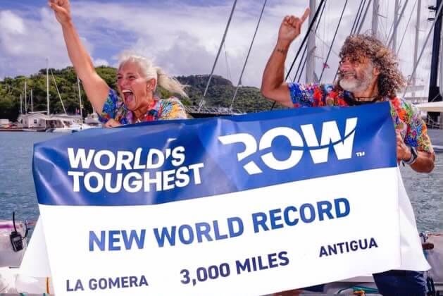 Dawn Smith and Paul Lore celebrating with a new world record banner after their Atlantic row
