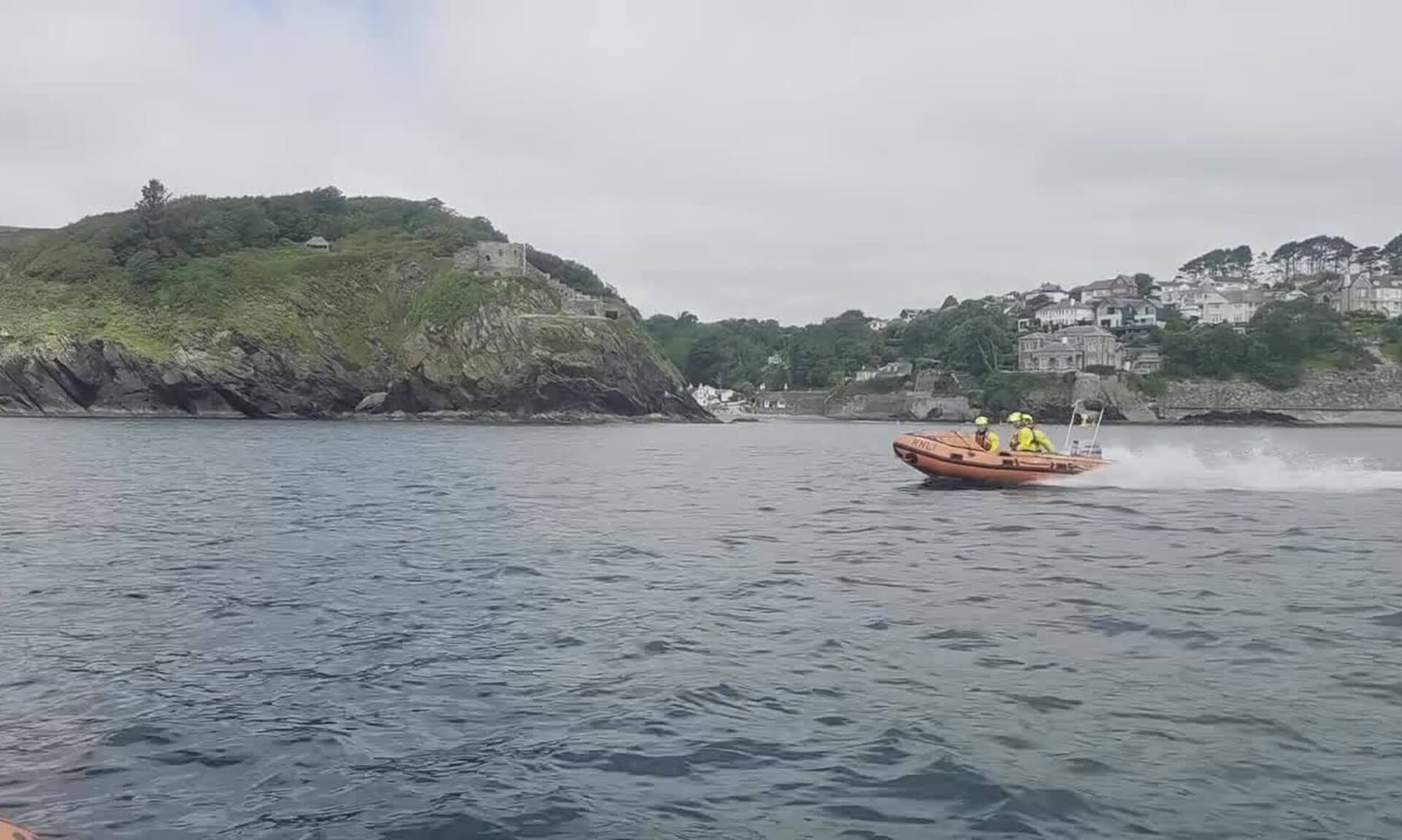 Fowey RNLI D class lifeboat crew heading out past St Catherine's Castle
