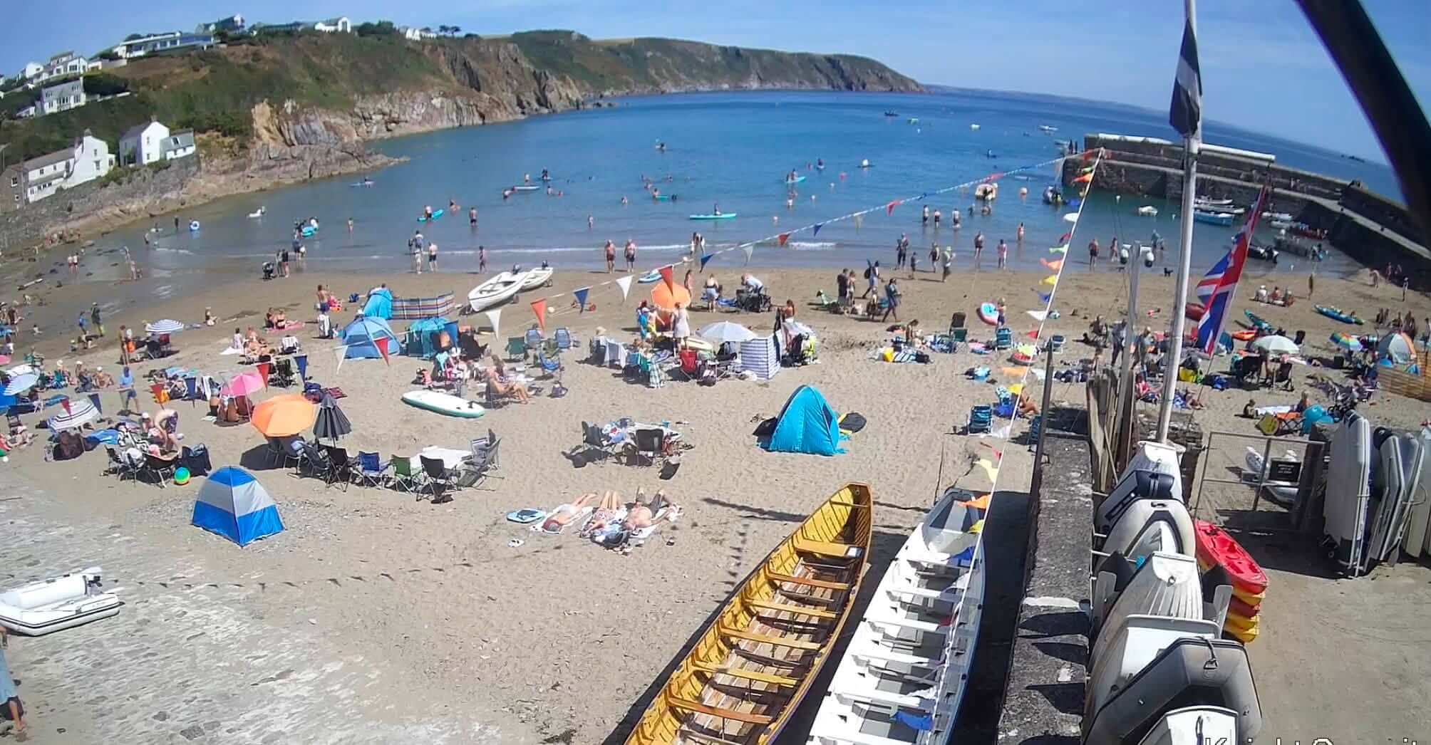 Busy summer day on the beach and harbour at Gorran Haven