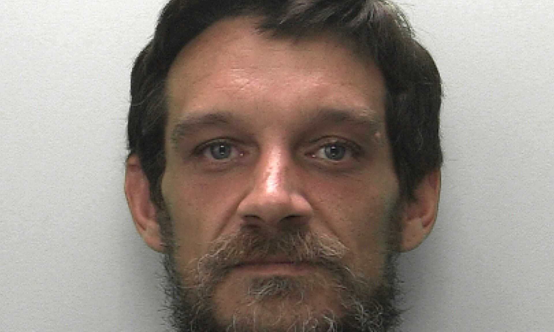 Police custody photo of wanted man Greg Coombes