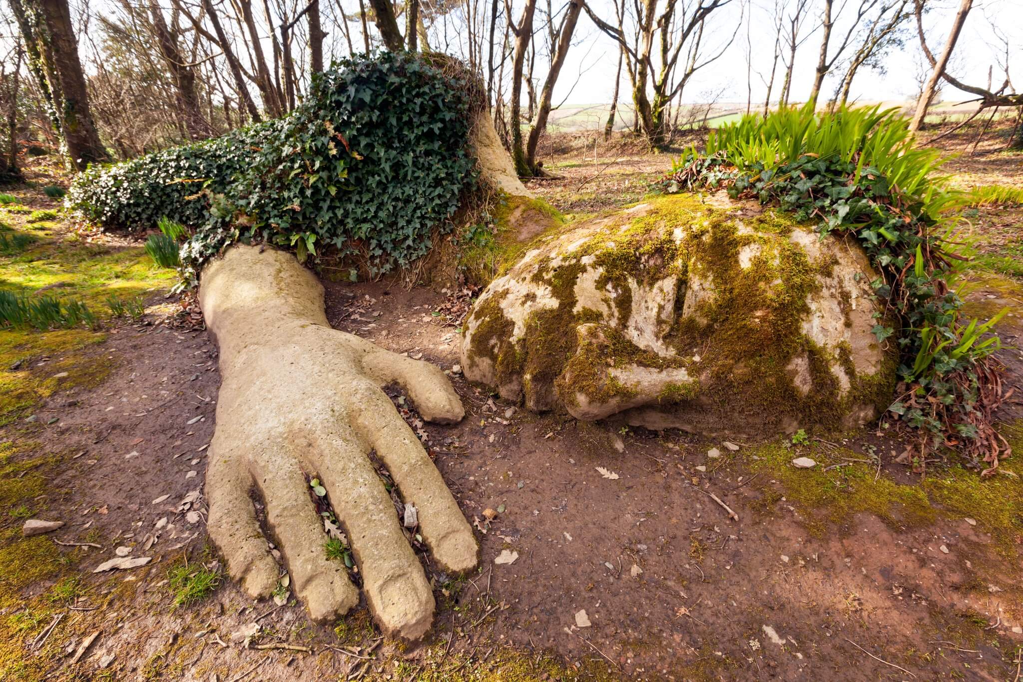 The Mud Maid sculpture at Heligan, her hand and turfed head covered in winter ivy