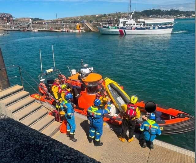 Rock RNLI lifeboat alongside the pontoon at Padstow harbour with coastguard and rescue crews