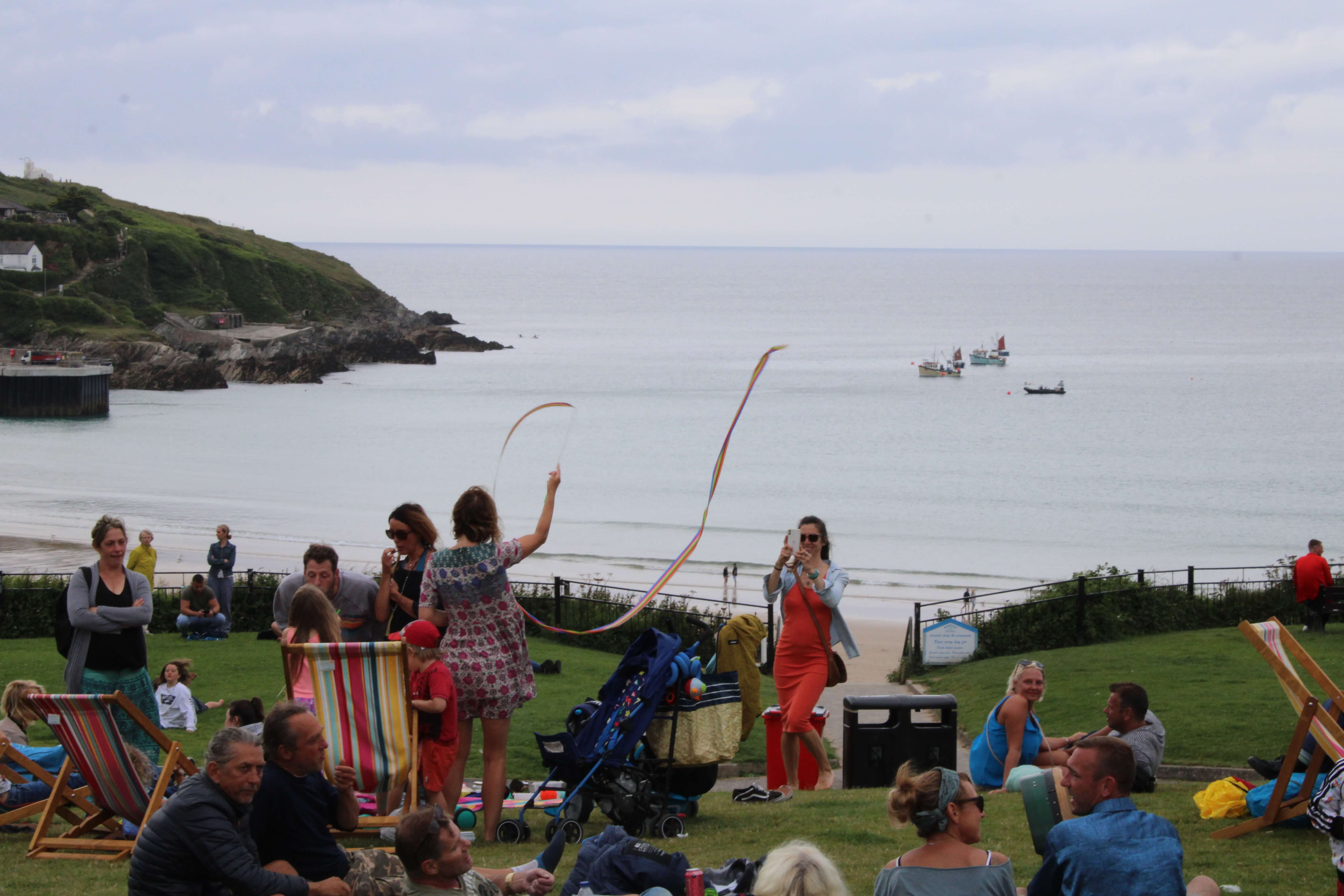 Crowds relax in deckchairs on the grass at the Killacourt in Newquay overlooking the harbour