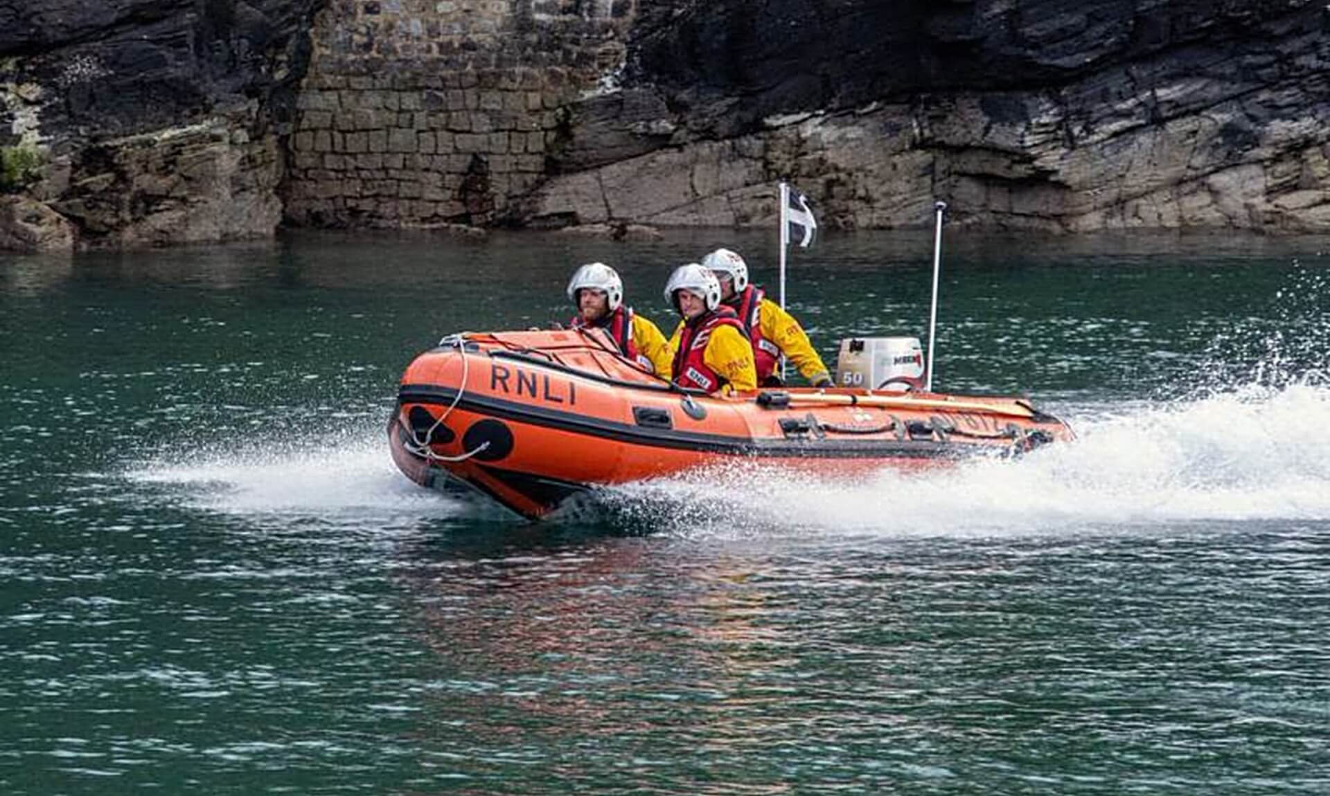 Looe RNLI D Class inshore lifeboat crew on the river at speed