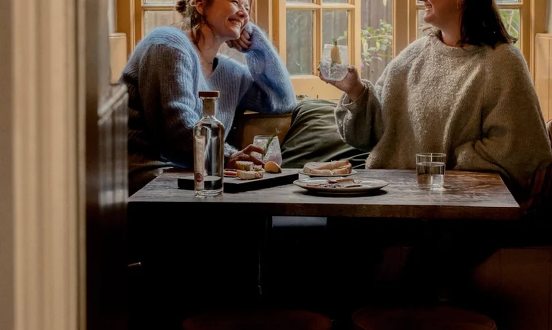 Loveday Distillery founders Chloe and Daisy at a table with gin and glasses