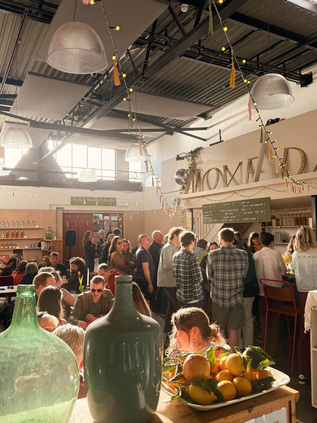 Busy Loveday Distillery taproom with people gathered under the sign
