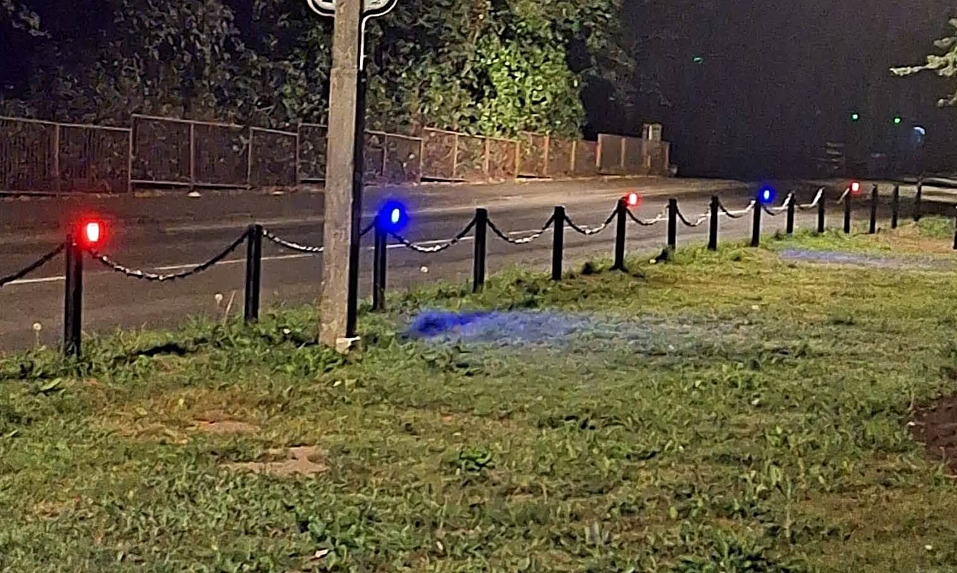 Red and blue lights along the bollards of Mevagissey's Cornerways and Valley Road garden area at night