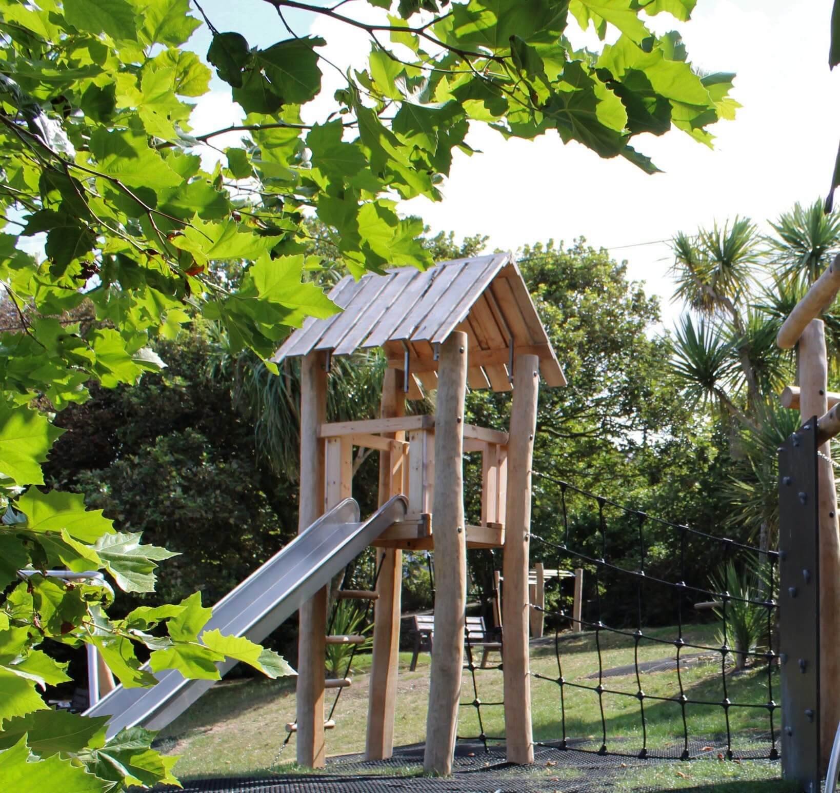 New wooden play tower and slide at Mount Wise, Newquay, with the council's safety notice overlay