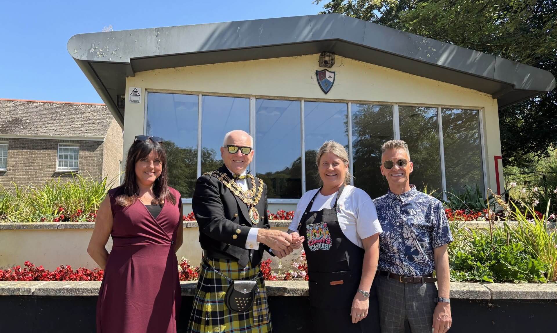 The Mayor of Bodmin shakes hands with the owner of Cammy's Little Castles outside Narisa Hall at Priory Park, with two council officers alongside