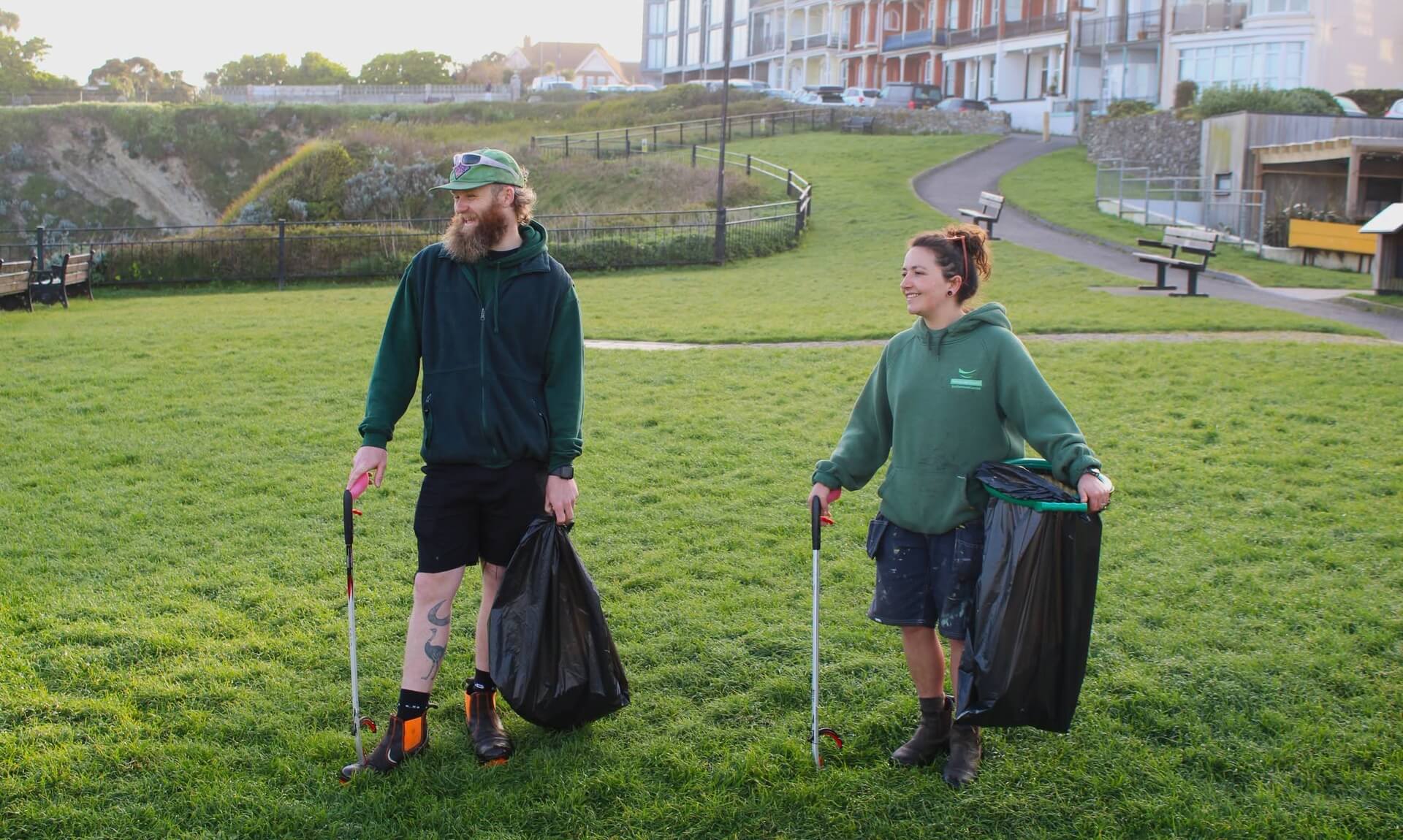 Two Newquay Town Council staff litter picking on open grassland
