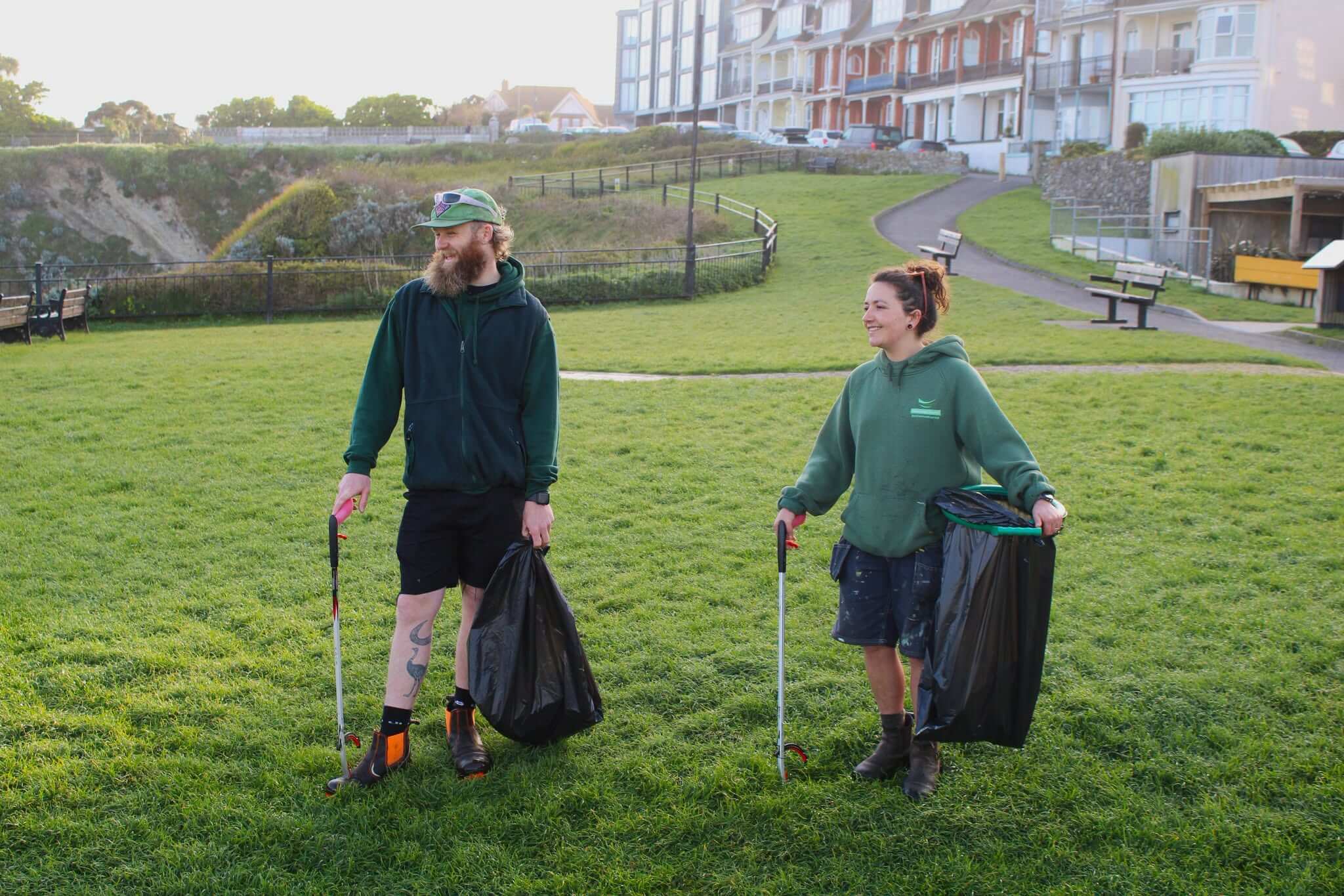Two Newquay Town Council staff litter picking on open grassland