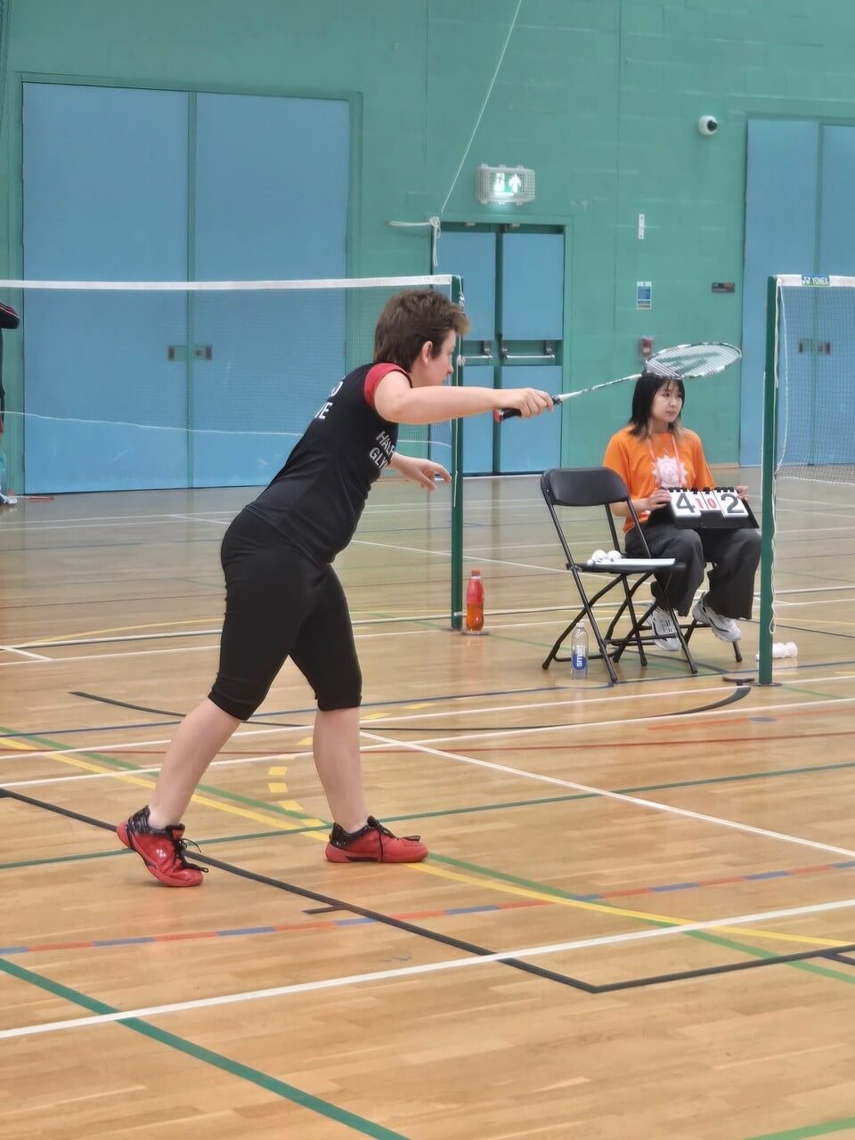 Nikki Welch playing a shot in front of the umpire and scoreboard
