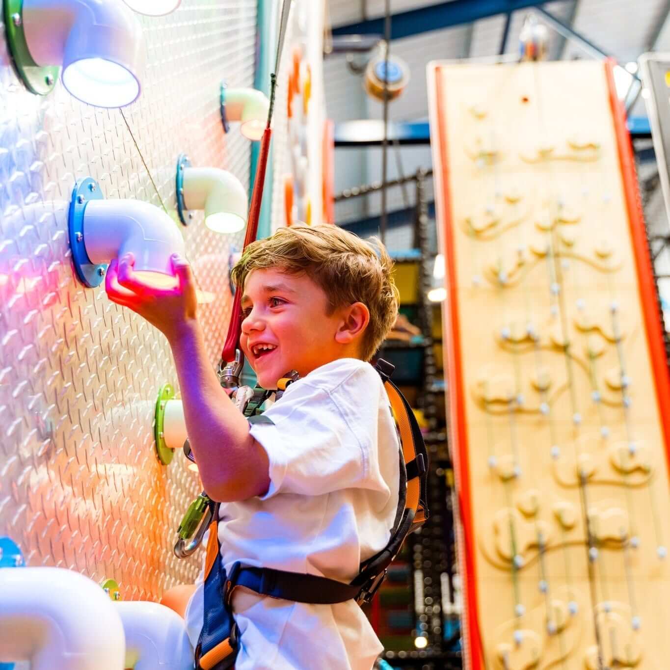 Boy on the interactive climbing wall at NQY Rocks