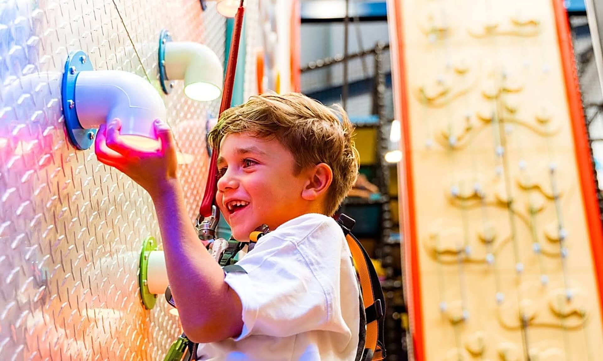 Boy on the interactive climbing wall at NQY Rocks