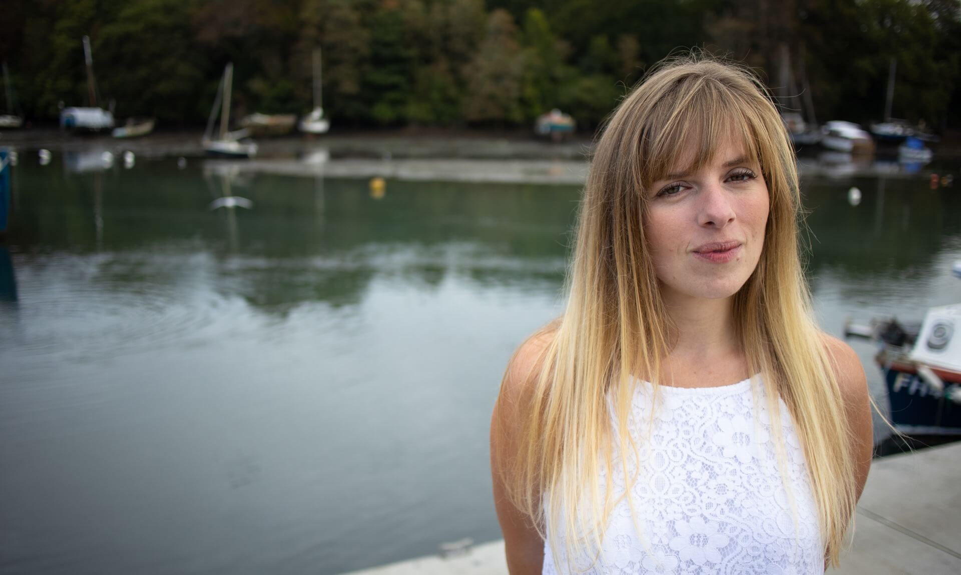 Katherine George of Oh So Social standing beside the water in Cornwall