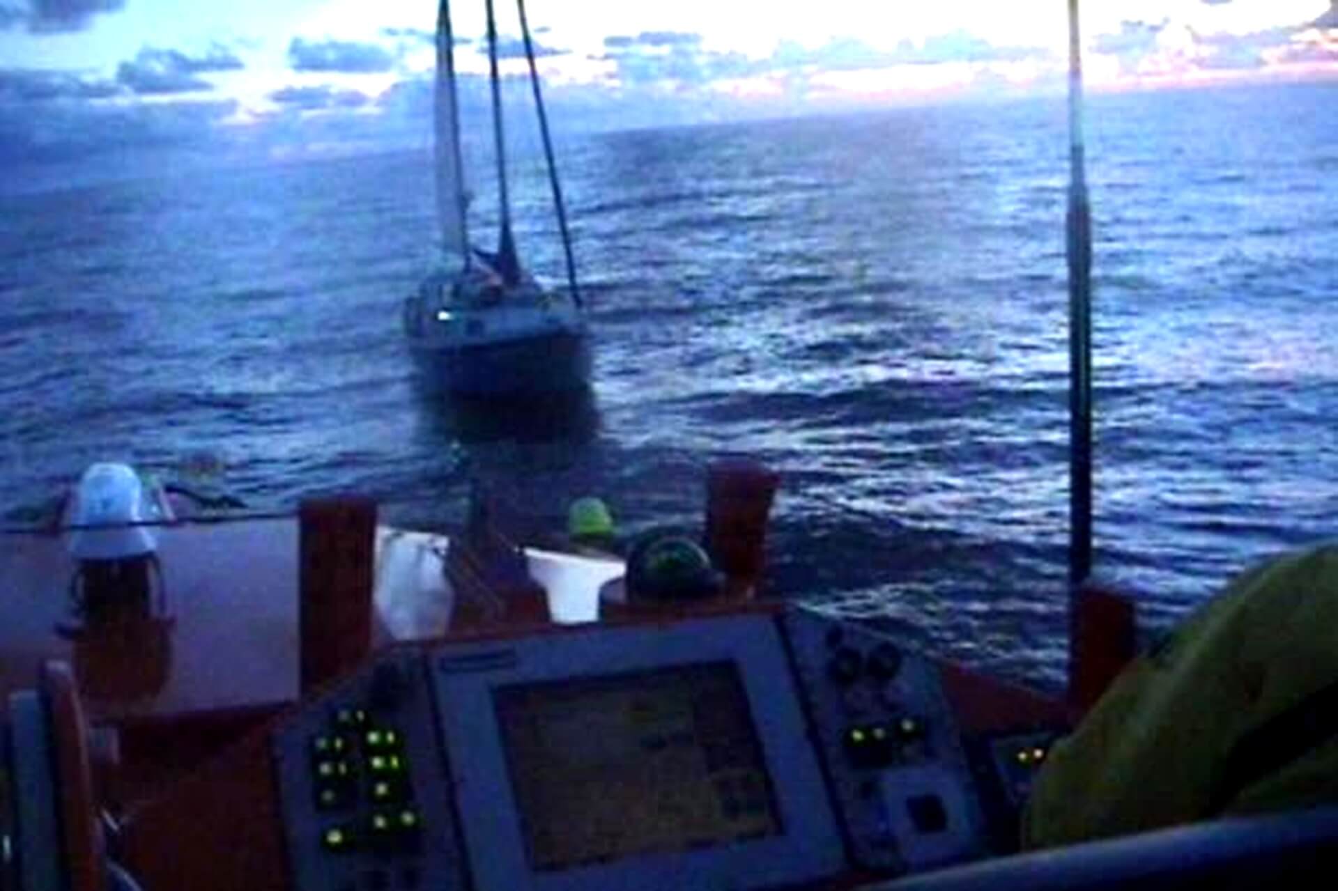 A yacht at dusk off Bude viewed from Padstow RNLI lifeboat's helm before being taken under tow to the Camel Estuary