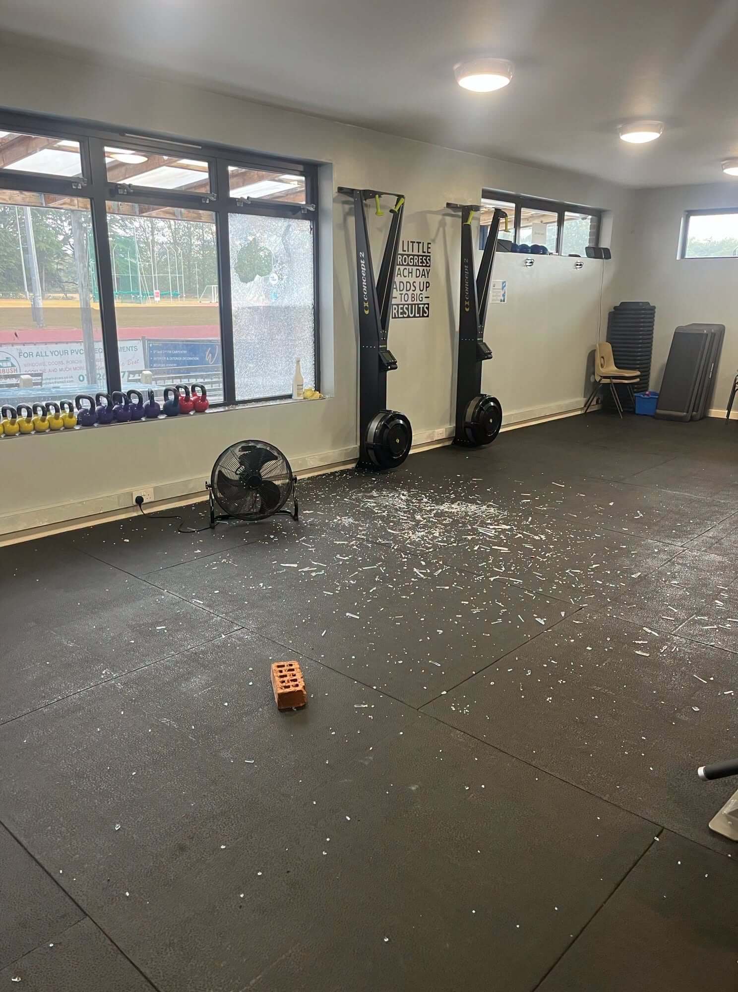 Broken glass and a brick on the floor of the Par Track gym after windows were smashed