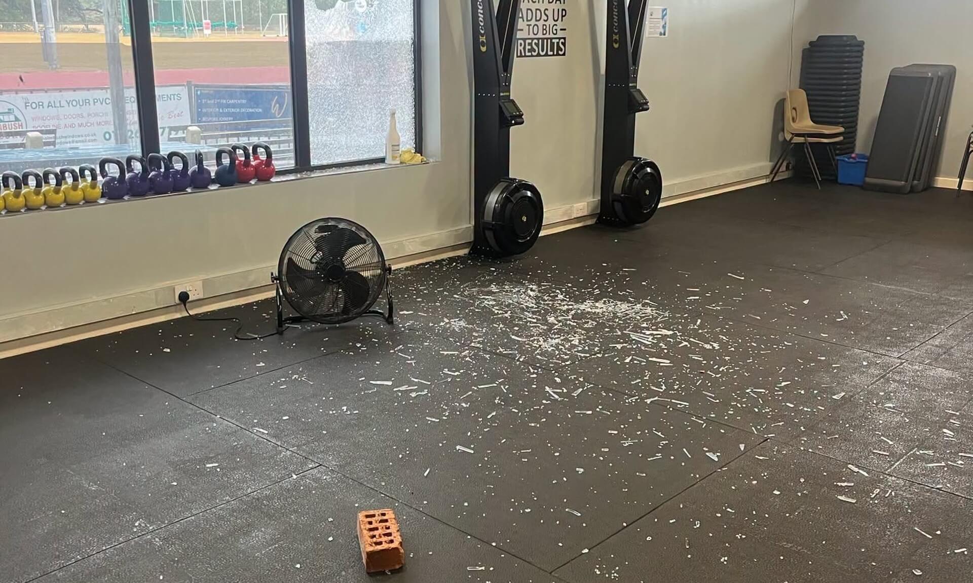 Broken glass and a brick on the floor of the Par Track gym after windows were smashed
