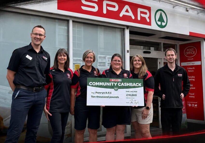 Six people stand outside a SPAR store holding a large Community Cashback cheque made out to Penryn R.F.C for ten thousand pounds