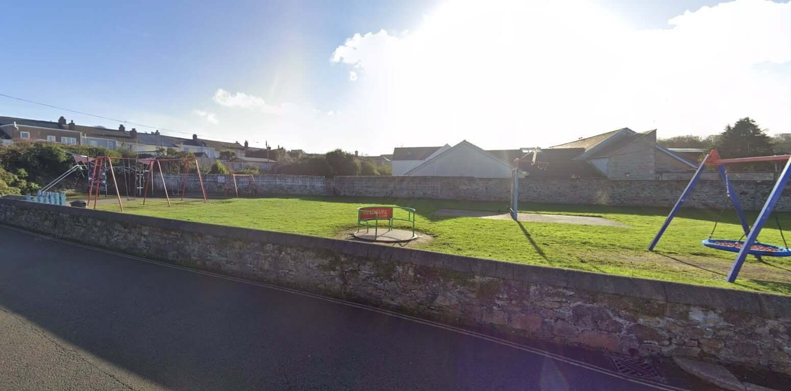 Plain-an-Gwarry Park play area in Redruth seen from the road, showing swings, a basketball hoop and the roundabout being removed