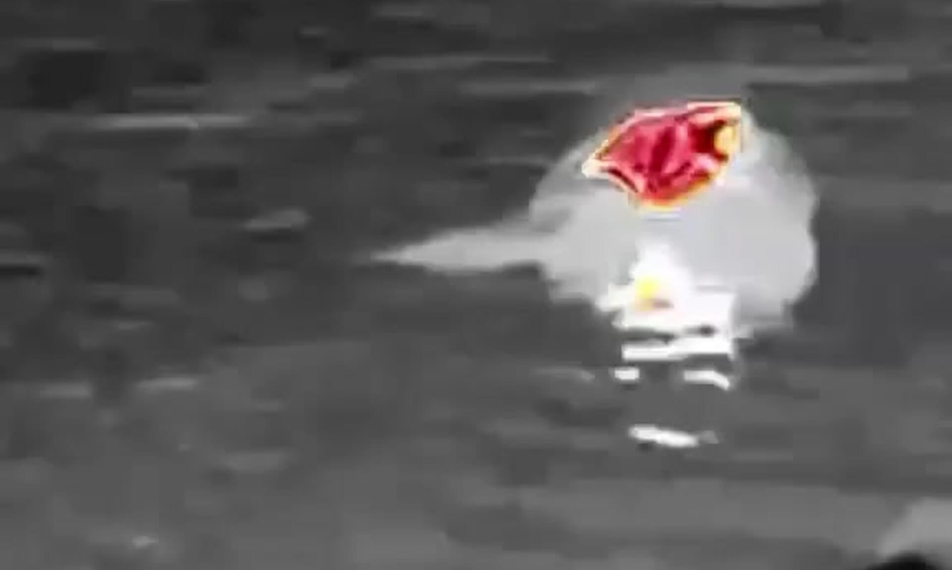 Thermal camera view of a rescue dummy floating in dark water, its lifejacket glowing red and orange