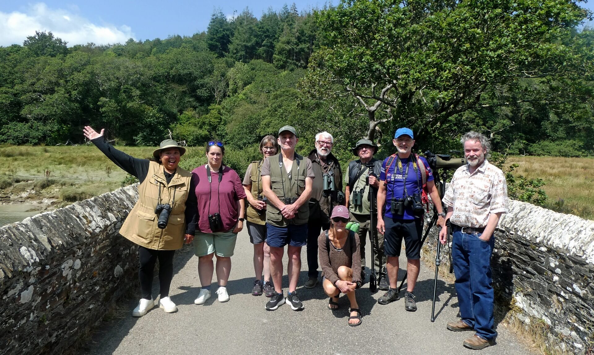 Group of birdwatchers on a stone bridge at Ruan Lanihorne on the Roseland Peninsula