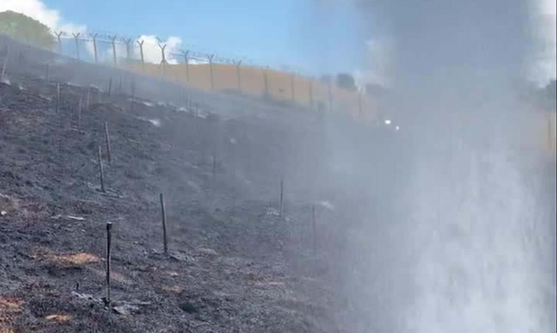 Scorched hillside with a firefighting water jet during the Devon wildfire