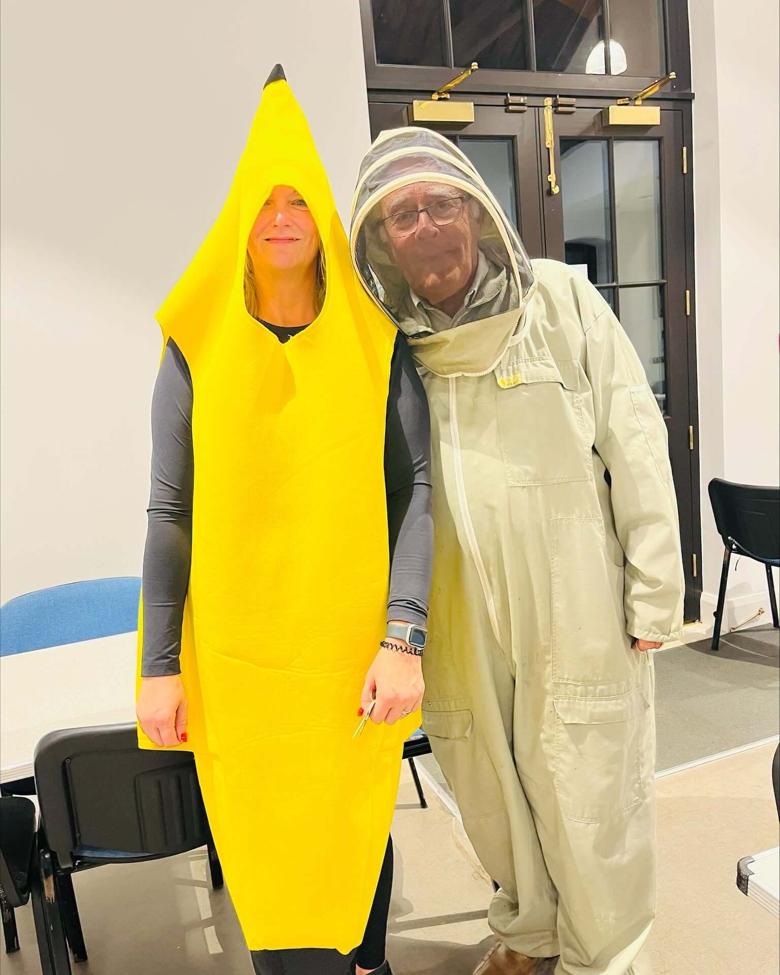 A quiz-goer in a banana costume beside another in a beekeeper suit