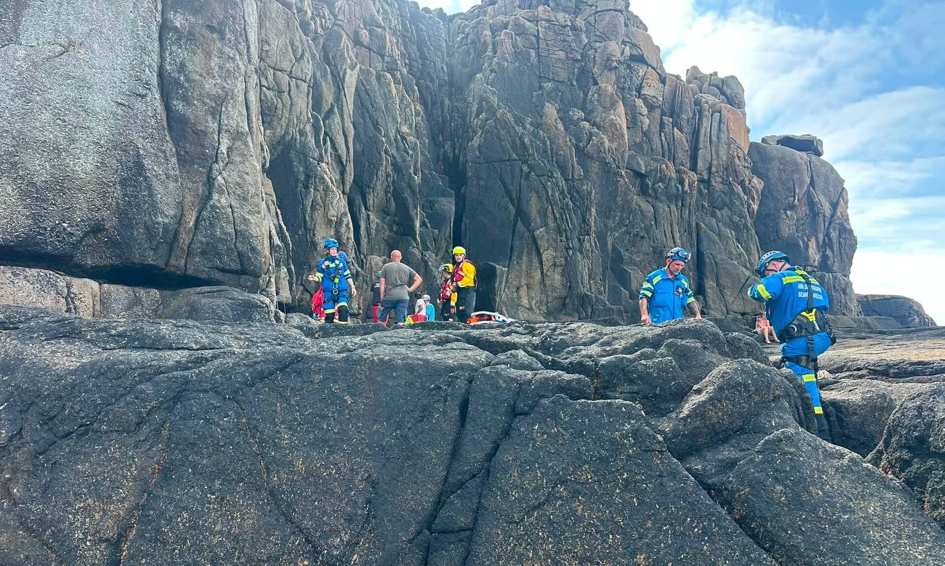 Coastguard and ambulance crews at the base of a granite cliff near Sennen Cove