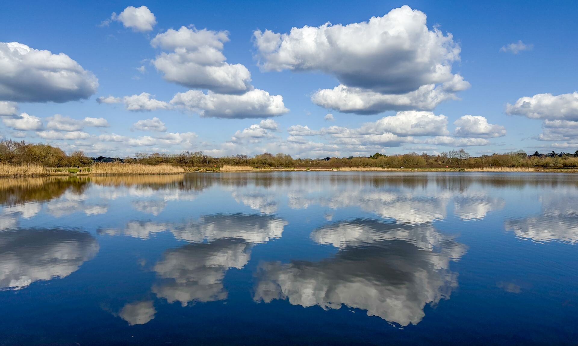 Clouds reflected in the still water of a lake managed by South West Lakes Trust
