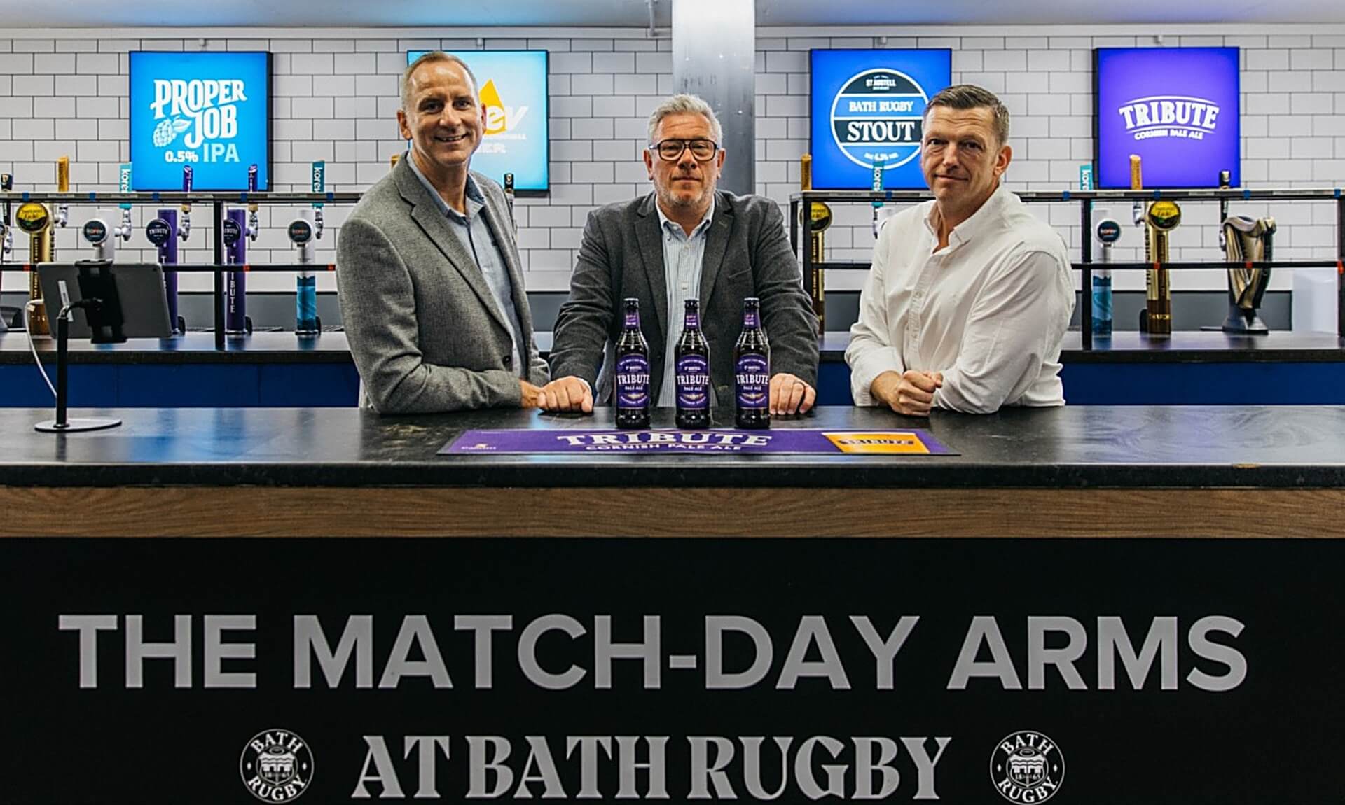 Dan Crabb of St Austell Brewery with Bath Rugby representatives at the Tribute Stand bar