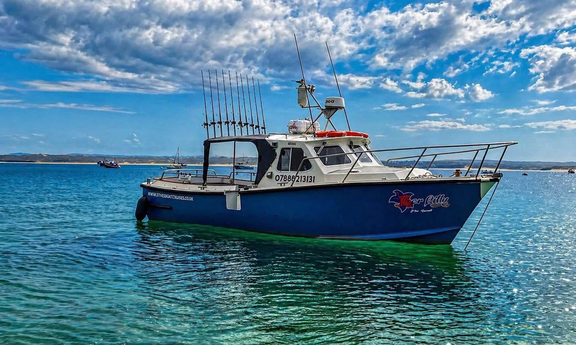 The Tiger Lily boat moored on bright turquoise water off St Ives