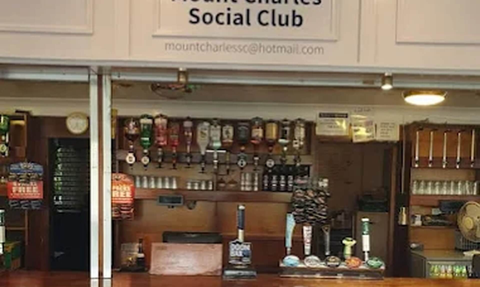 The bar and Welcome to Mount Charles Social Club sign inside the club in St Austell