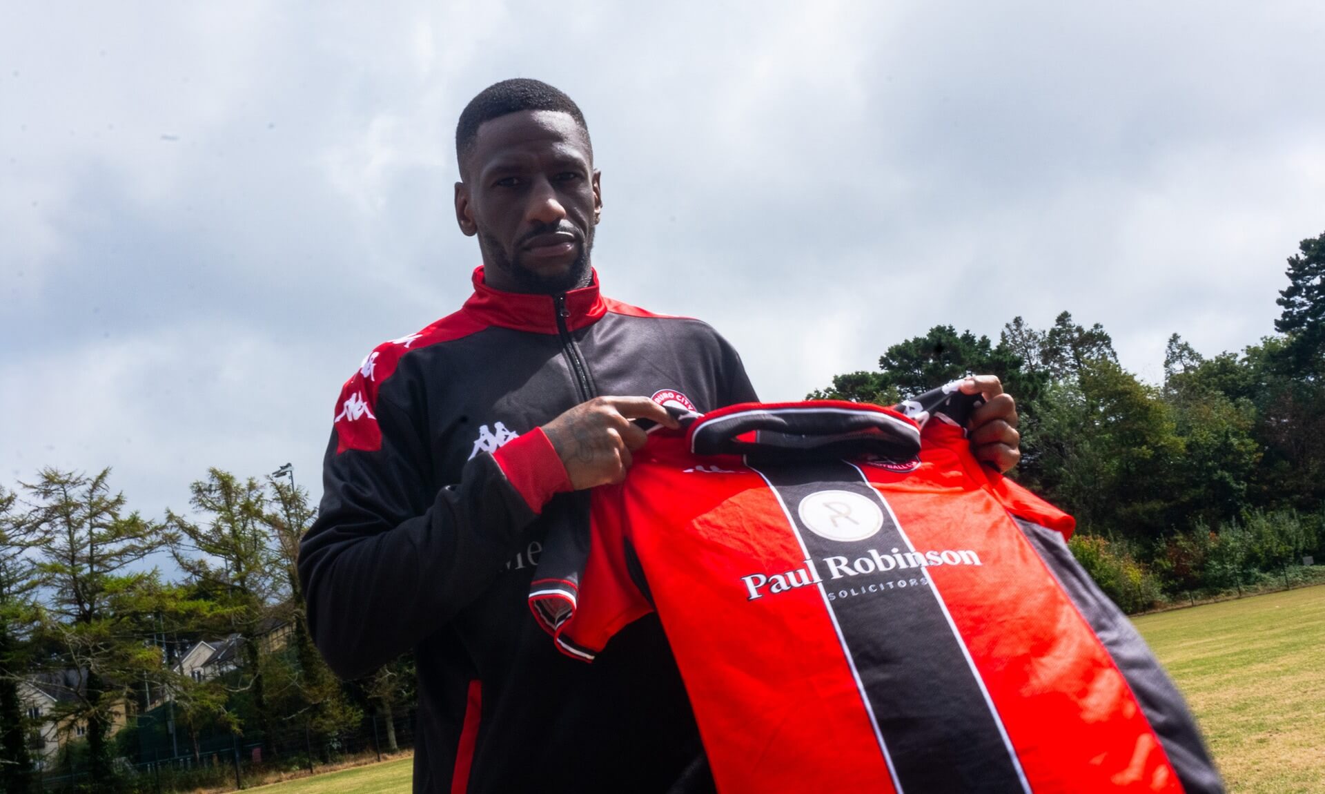 Omar Bogle holding a Truro City shirt