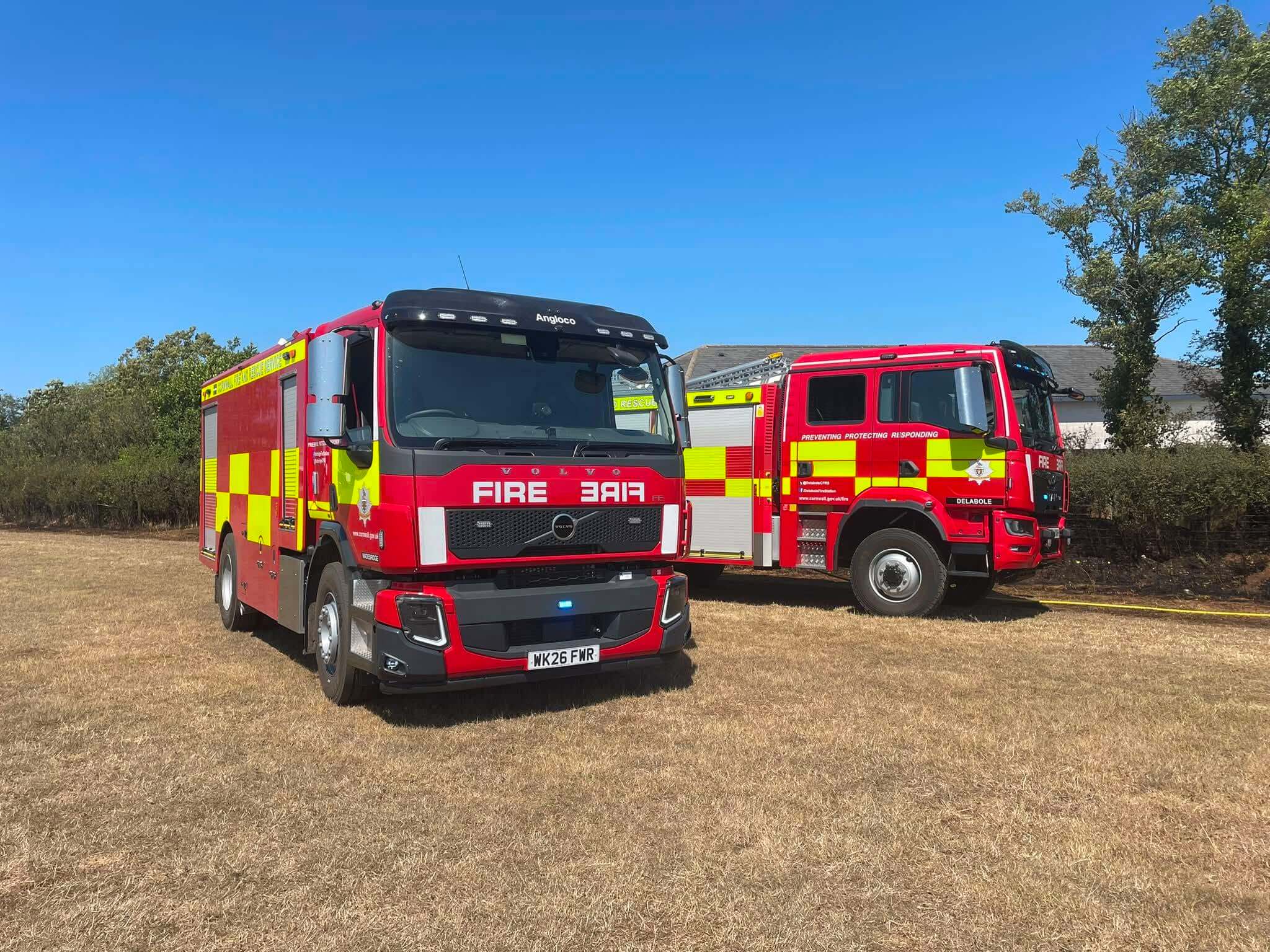 A Wadebridge and a Delabole fire appliance parked in a dry, scorched field