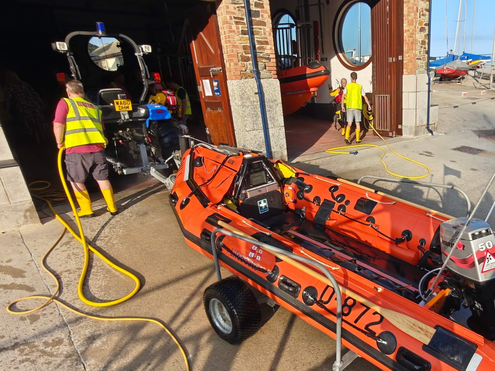 Looe RNLI shore crew washing down the D Class lifeboat after returning from Plaidy