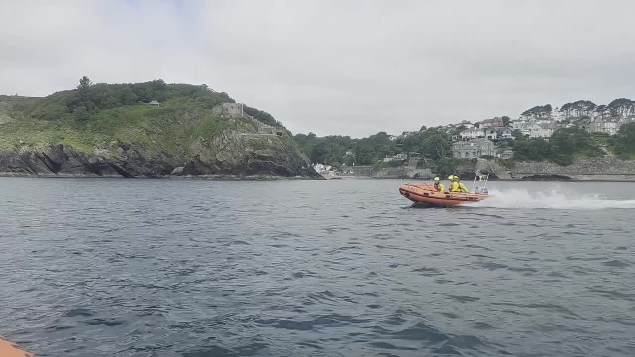 Fowey RNLI D class lifeboat crew heading out past St Catherine's Castle
