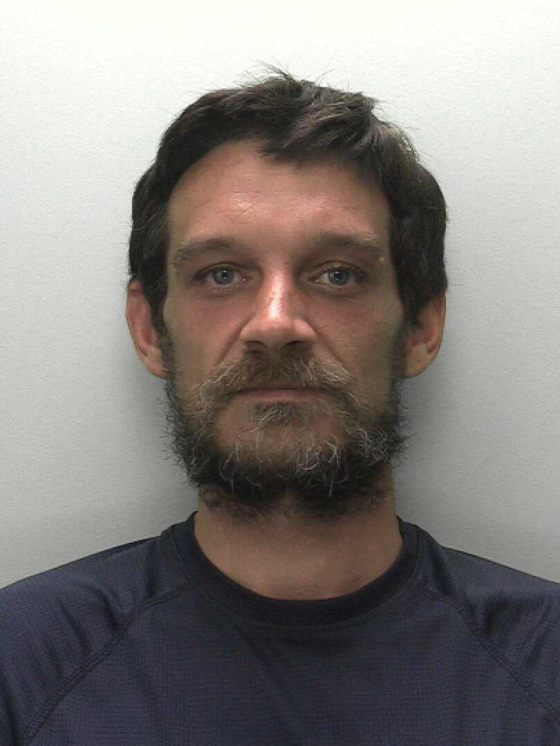 Police custody photo of wanted man Greg Coombes
