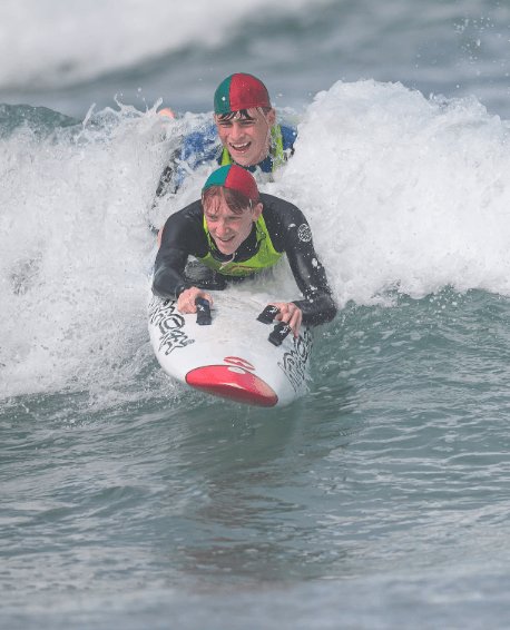 Two competitors bodyboarding through a wave