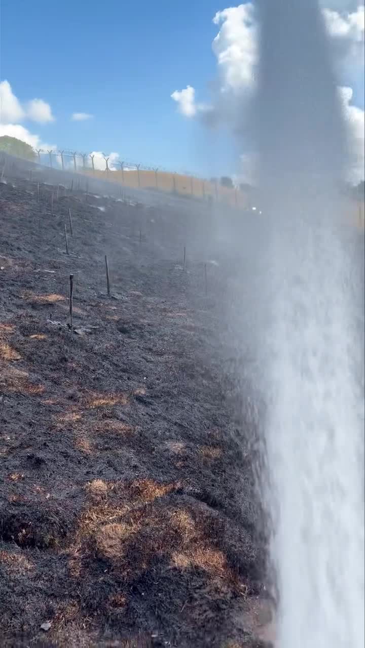 Scorched hillside with a firefighting water jet during the Devon wildfire